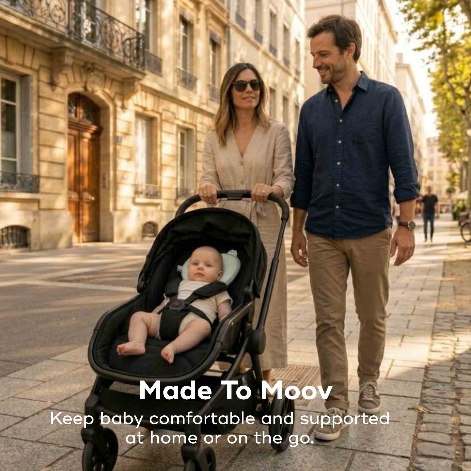 Man and woman walking with a baby in a stroller on a city street. #color_Sage